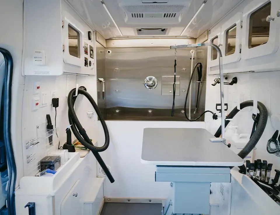 Inside the van: the stainless tub, the grooming table and dryer hoses